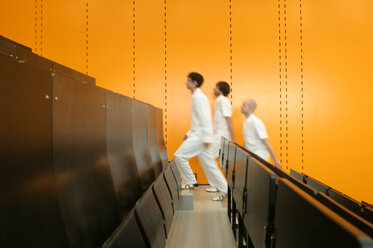 Three men walking up stairs in theatre - 00119BM-U