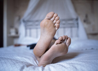 Person lying on bed, close up of feet - 00097PE