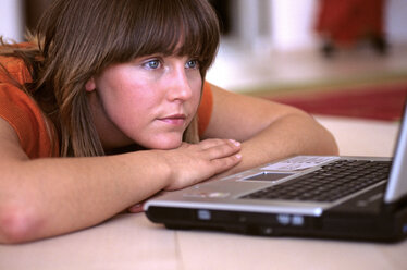 Frau liegend, Blick auf Laptop - DK00087