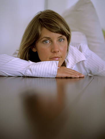 Woman leaning on table, close up, lizenzfreies Stockfoto