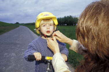 Mother adjusting son's (3-5) cycling helmet - 00809MS