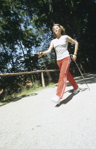 Frau geht mit Stöcken, Nordic Walking, lizenzfreies Stockfoto