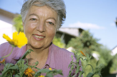 Senior woman in front of flowers, close-up - PEF00327