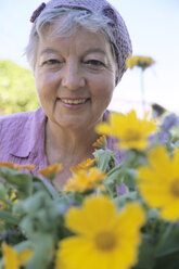 Ältere Frau vor Blumen, Nahaufnahme - PEF00323