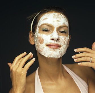 Young woman applying face pack, close-up - JLF00008