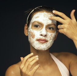 Young woman applying face pack, close-up - JLF00007