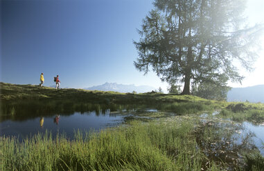 Österreich, Salzburger Land, zwei Menschen wandern durch die Berge - HHF00046