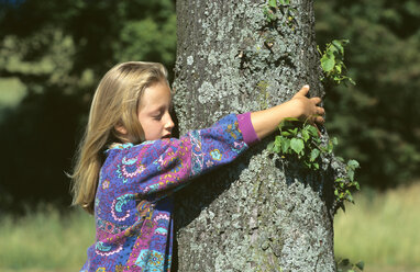 Girl embracing tree, side view - CRF00552