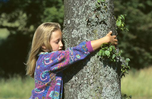 Mädchen, das einen Baum umarmt, Seitenansicht - CRF00552