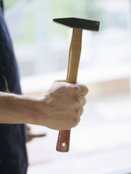 Man holding hammer, midsection - PEF00354
