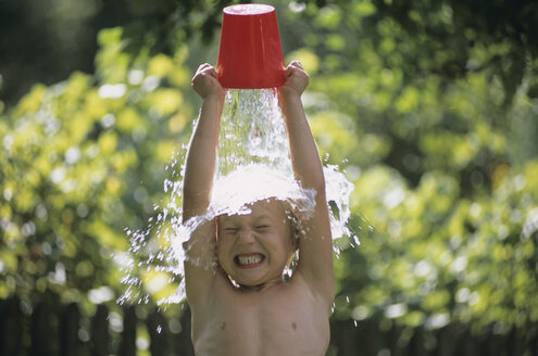 Junge, der sich Wasser über den Kopf gießt, im Freien - HHF00059