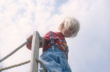 Child (4-5) on railing, low angle view - 00489CR