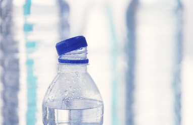 Midsection Of Man Holding Water Bottle While Standing Against Wall stock  photo