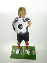 Boy (8-11) holding football on pitch - LMF00017