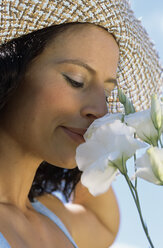 Young woman smelling flower, close up - LDF00090