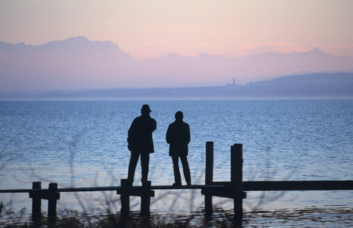 Silhouette eines Mannes und einer Frau auf der Uferpromenade, Rückansicht, Ammersee, Bayern, Deutschland - UMF00111