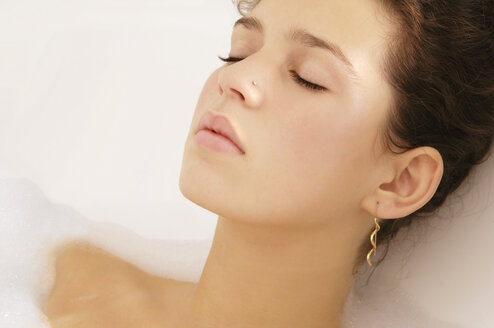 Young woman relaxing in bubble bath, close-up - LRF00005