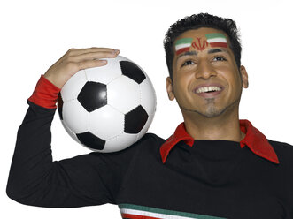 Junger Mann mit iranischer Flagge im Gesicht, der einen Fußball hält - LMF00312