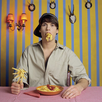 Young man eating French fries - JLF00029