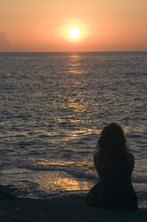 Woman watching sunset at the beach - LDF00114