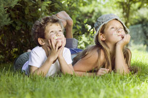 Junge und Mädchen (6-9) liegen im Gras und schauen nach oben - CKF00108