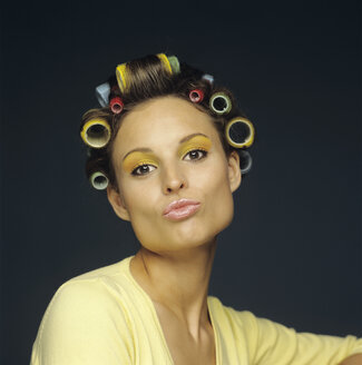 Woman with rollers in hair pouting, close-up, portrait - JLF00083