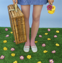 Young woman carrying picnic basket, low section - JLF00064