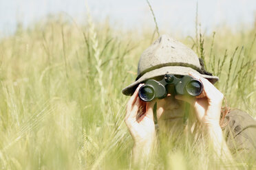 Junge Frau mit Fernglas in einem Weizenfeld - CLF00050