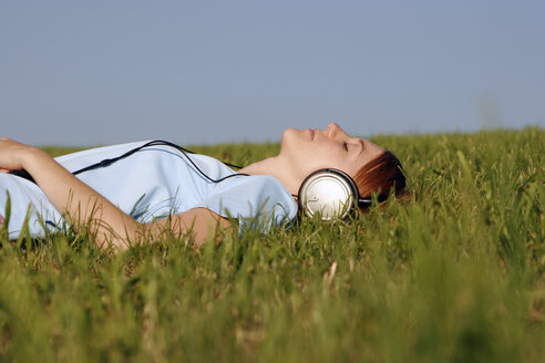 Frau liegt im Gras und hört Musik - CLF00044