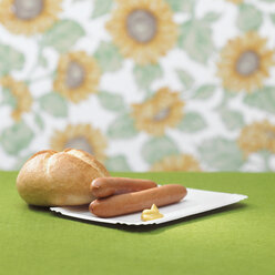 Wiener with mustard and bread roll on table - CHKF00023