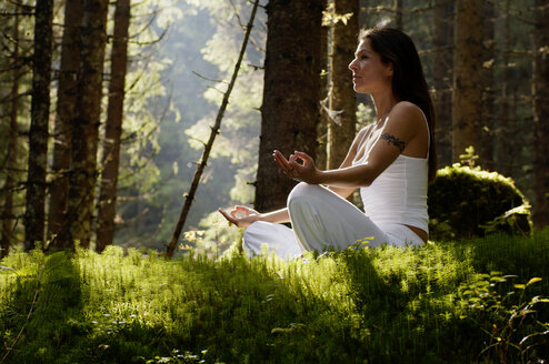 Young woman mediating in forest - HHF00131