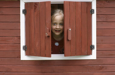 Mädchen (6-7) schaut durch das Fenster, lächelnd - CRF00742