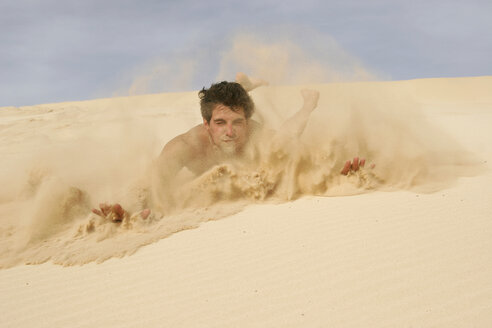 Mann rutscht auf Sand in der Wüste - RDF00074