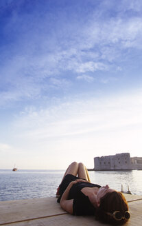 Kroatien, Dubrovnik, Frau auf Pier liegend - GSF00536