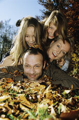 Family lying on autumn leafs, close-up, portrait - WEPF00289