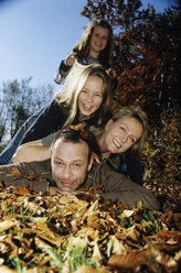 Familiy lying on autumn leafs - WEPF00287