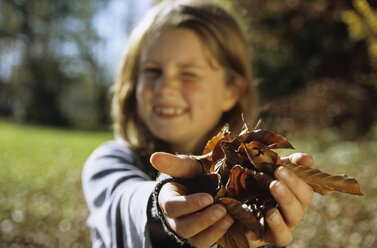 Mädchen (8-11) hält Blätter (Fokus auf Blätter) - WEPF00279