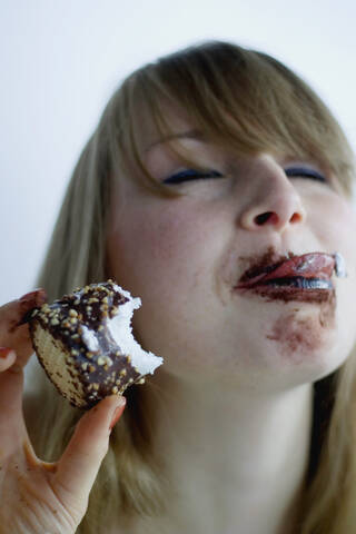 Young woman eating chocolate marshmallow stock photo