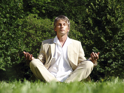 Man in meadow, meditating - DKF00097