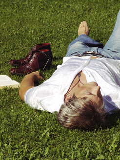 Man lying in grass, sleeping - DKF00094