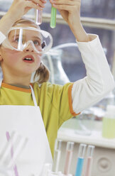 Girl (8-9) wearing protective goggles, holding test tube - WESTF00037