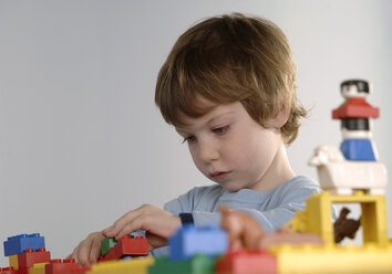 Junge spielt mit LEGO Steinen - CRF00844