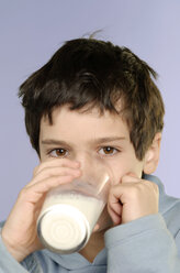 Junge (8-9), der ein Glas Milch trinkt, Nahaufnahme, Porträt - CRF00834