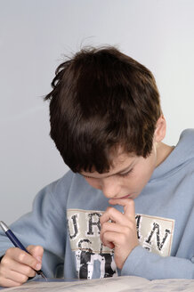 Boy (8-9) doing schoolwork, close-up - CRF00816