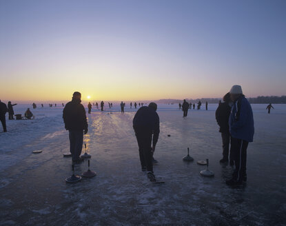 Deutschland, Bayern, Silhouette von Menschen beim Eisstockschießen - MOF00080