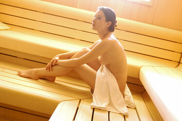 Naked woman sitting in sauna, side view - HHF00269