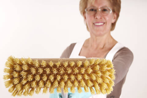 Mature woman holding broom stock photo