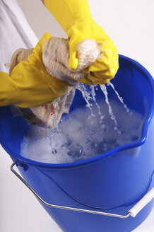 Woman wringing out cleaning rag, elevated view - 00023LRH-U