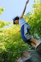 Boy (8-9) jumping, arms out - CRF00863