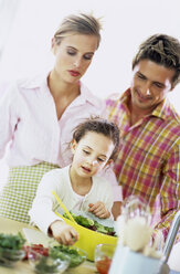 Parents watching daughter (6-7) prepare salad - WESTF00251